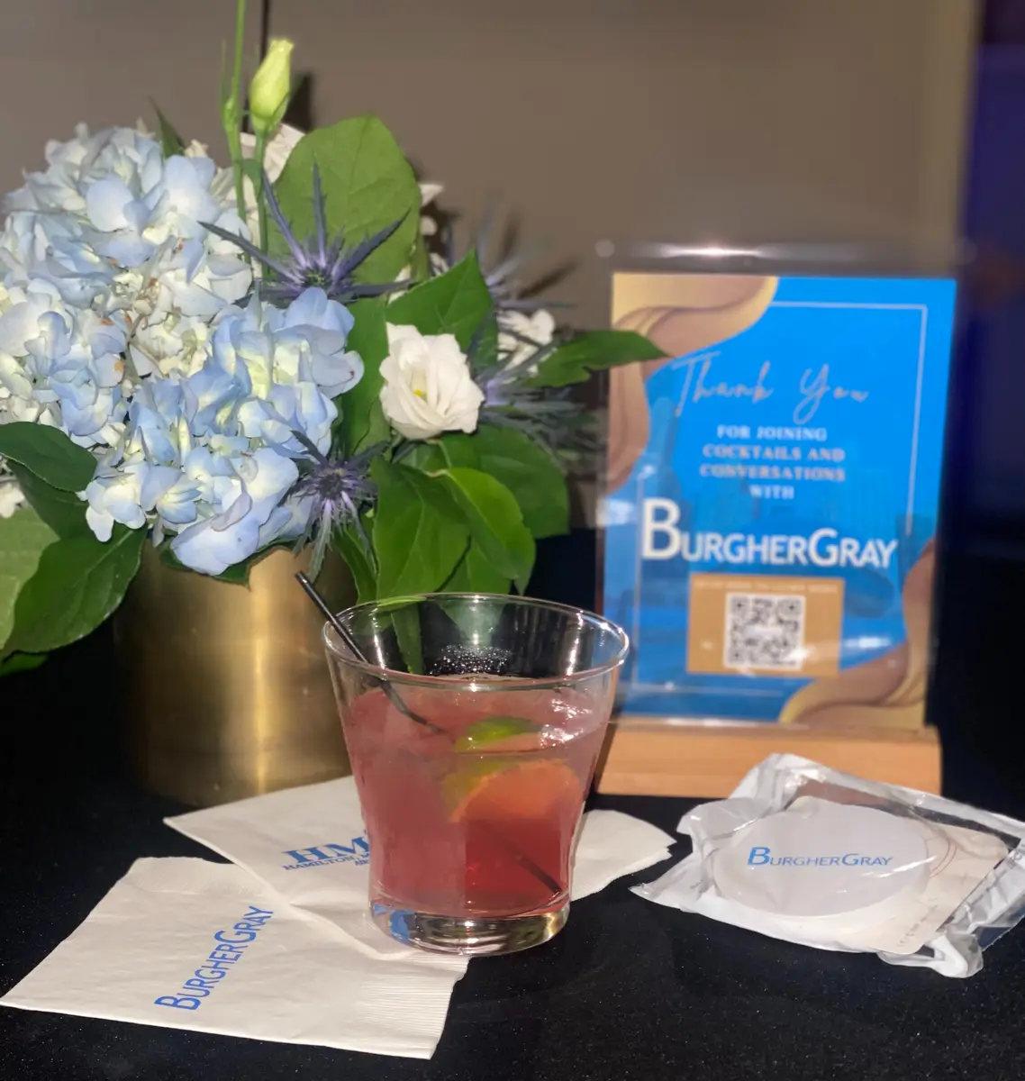 Cocktail and branded table setting at the Burgher Gray Cocktails & Conversations mixer