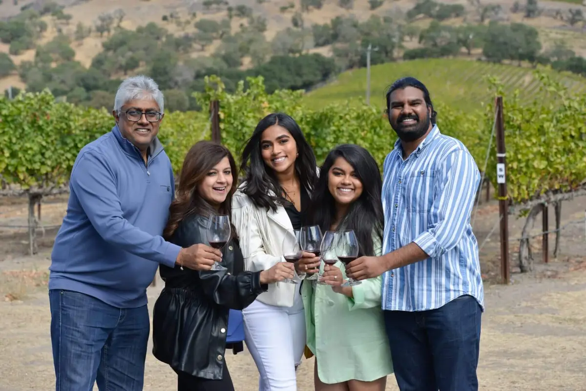 Happy customers toasting in a vineyard