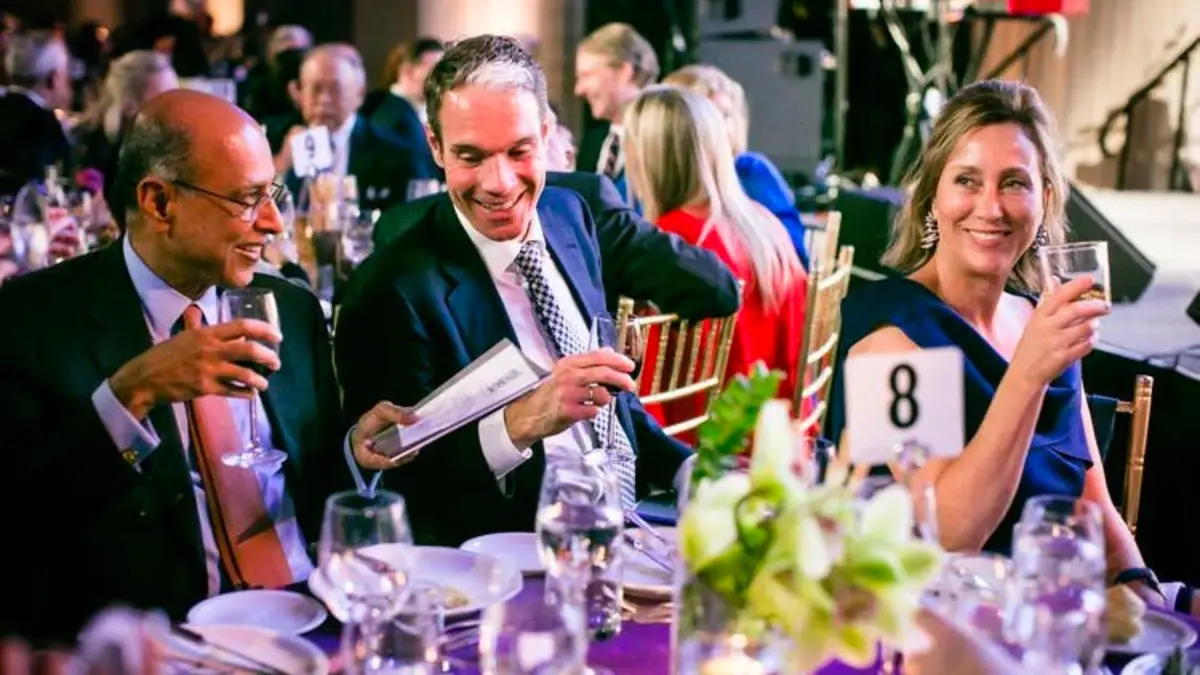 Guests raising glasses at a gala dinner
