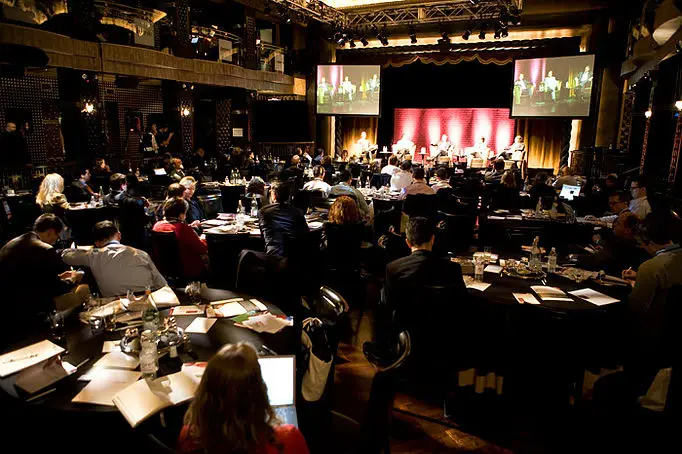 Conference in a ballroom with stage screens
