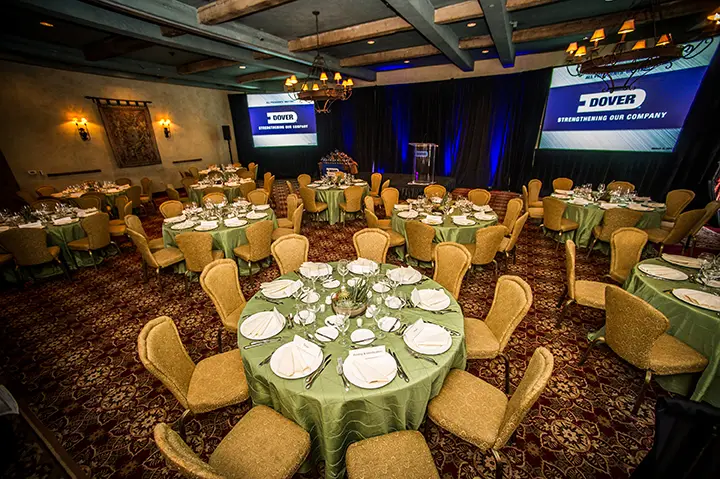 Banquet room with round tables and branded screens
