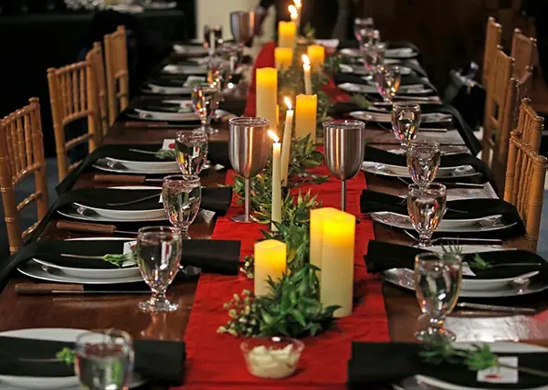 Long banquet table with candles and red runner