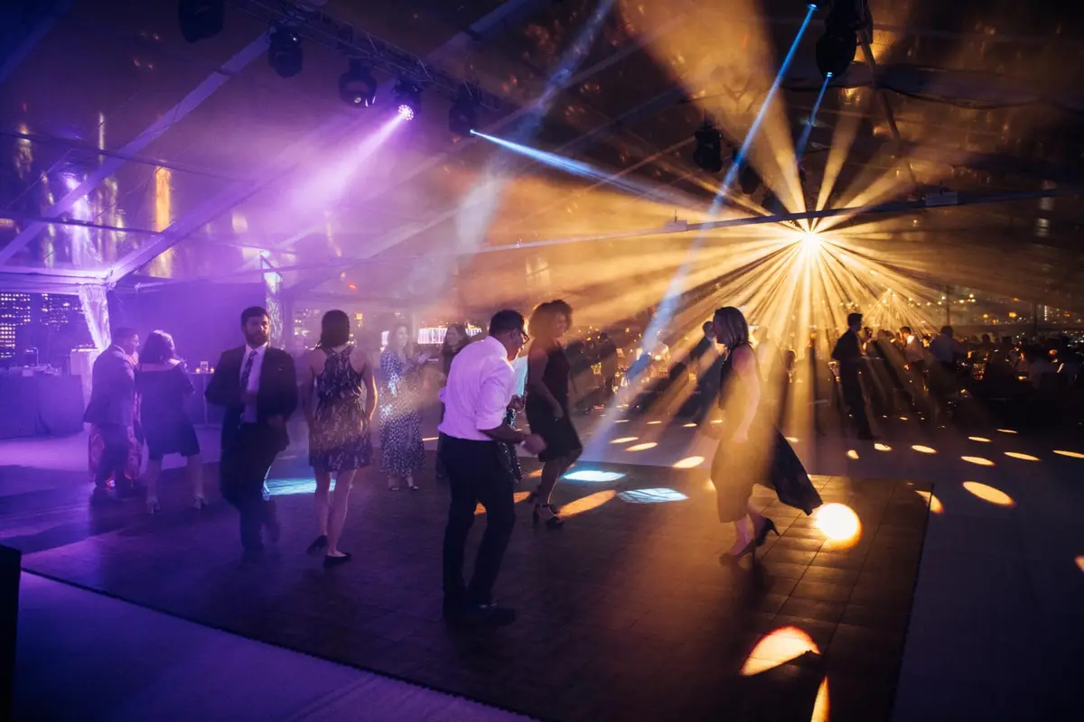 Guests at a black-tie event under dramatic stage lighting