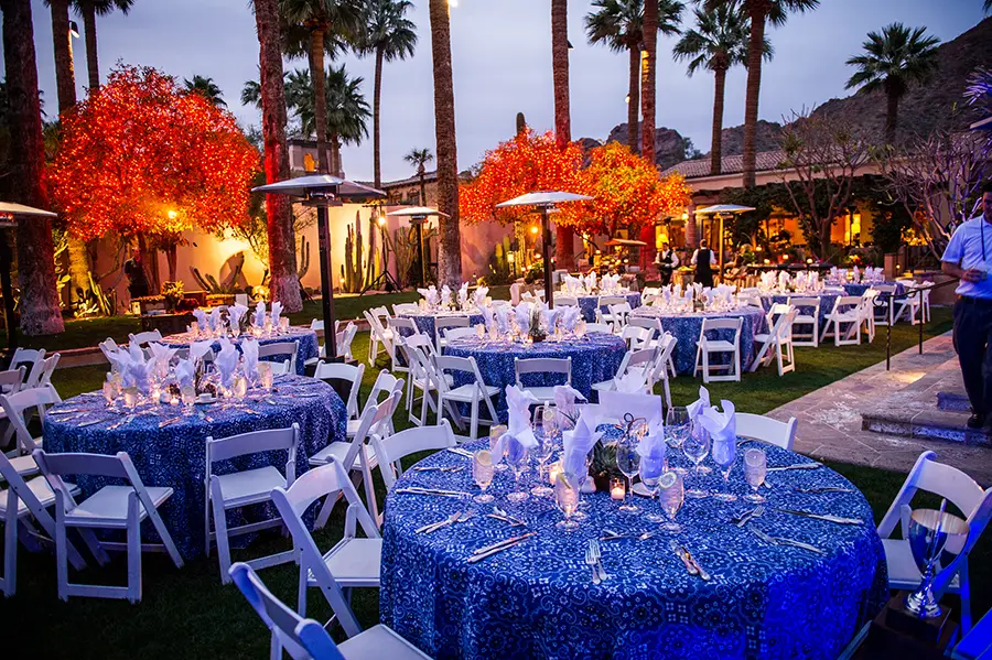 Outdoor dinner with blue sequin linens under palm trees