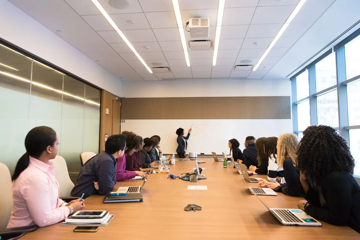 Colleagues discussing documents around a meeting table