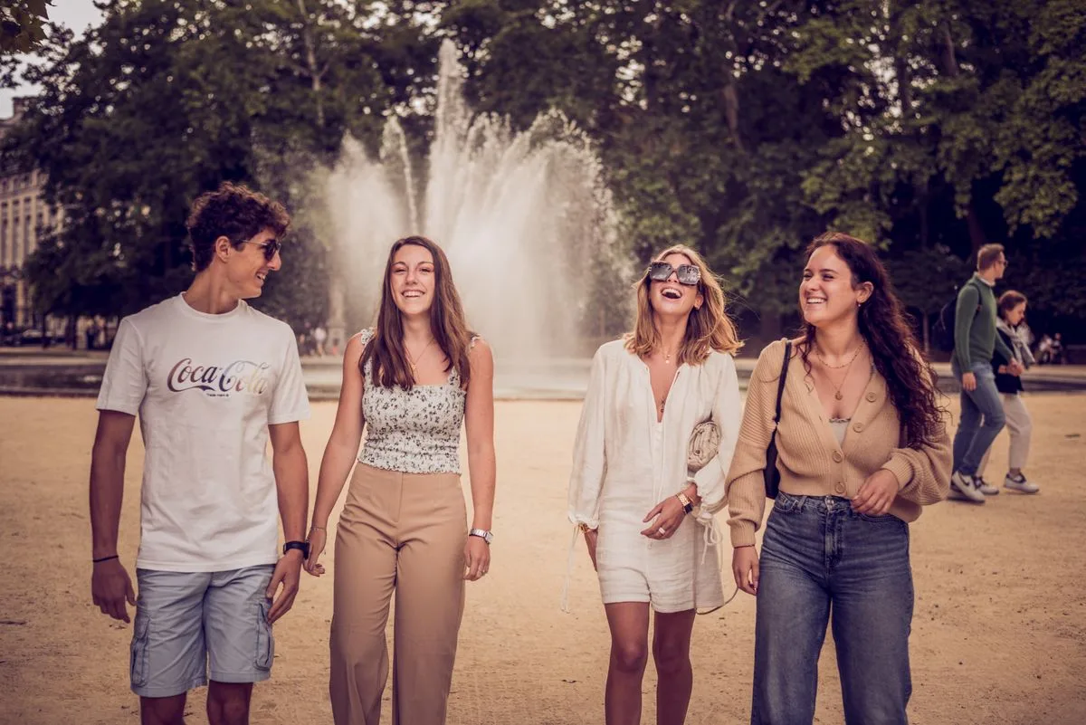 Friends walking together beside a fountain in a park