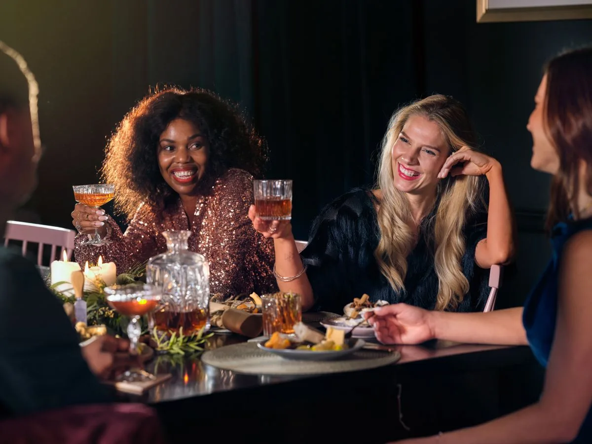 People sharing drinks and conversation over dinner