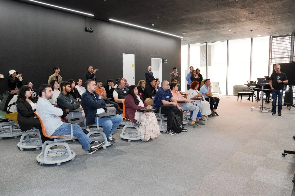 An audience listening to a presentation in a meeting room