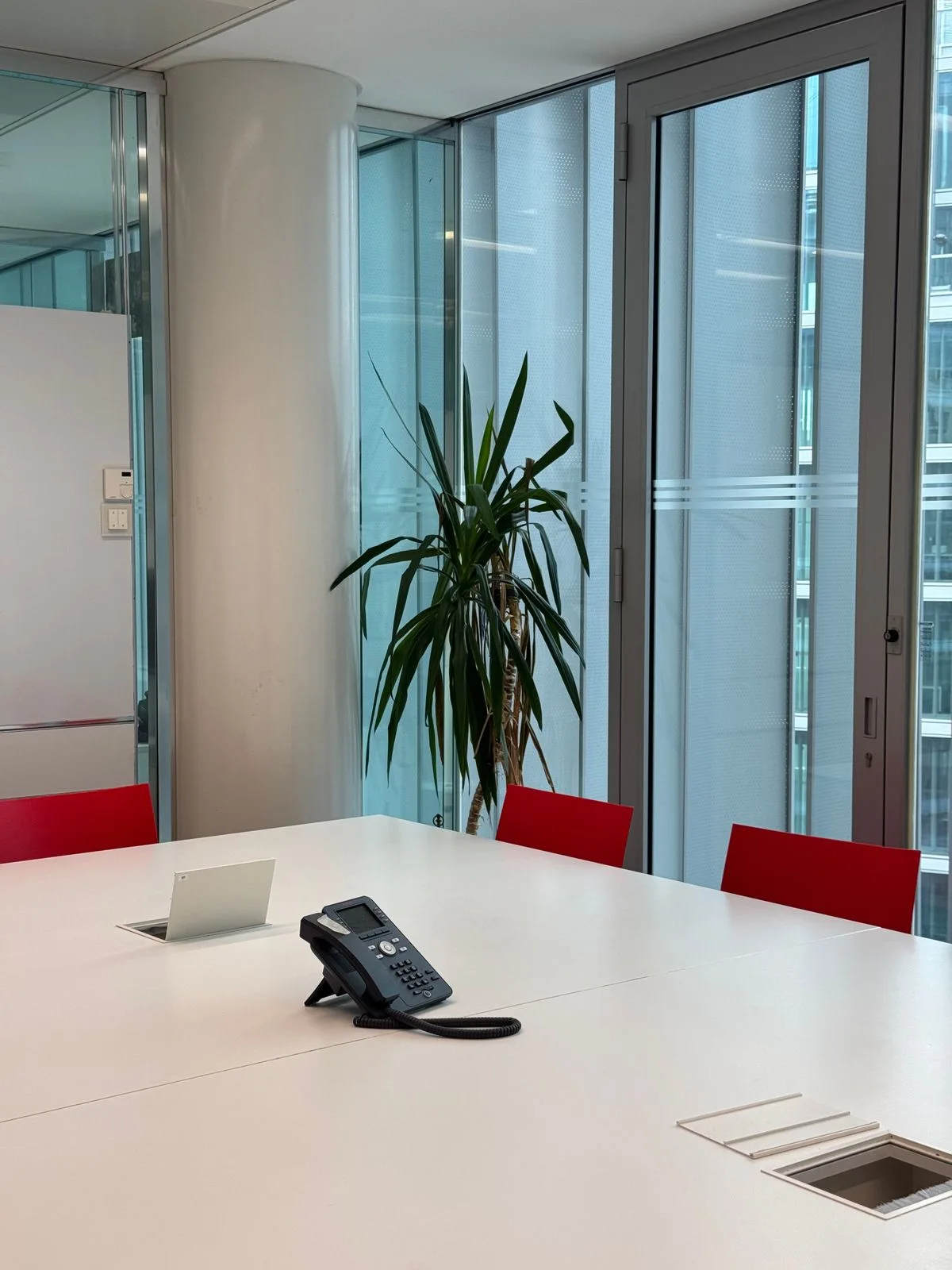 A meeting room with red chairs and large windows