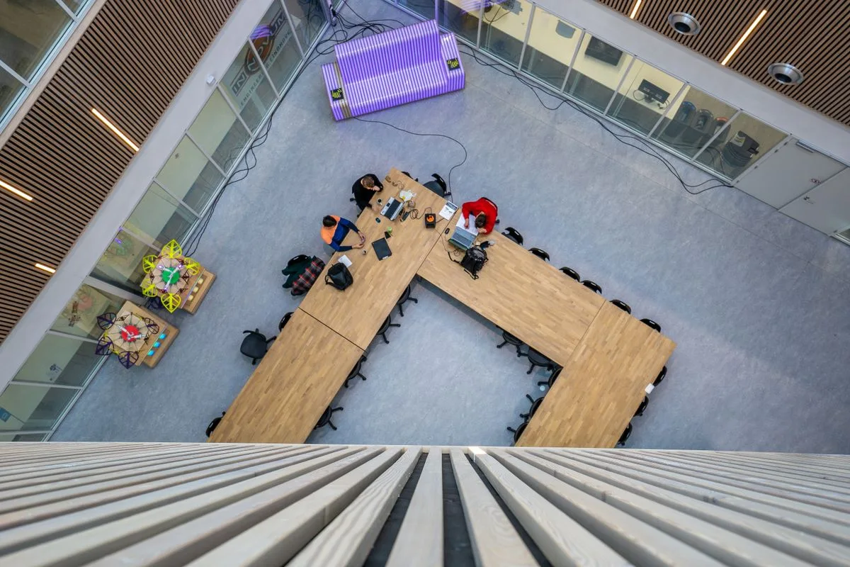 Colleagues working around a table in a large meeting space