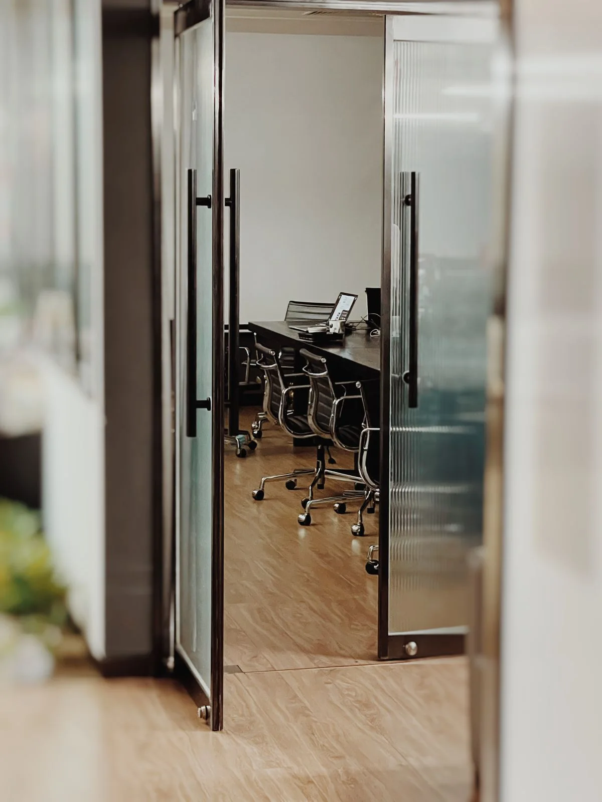 A meeting room viewed through open glass doors