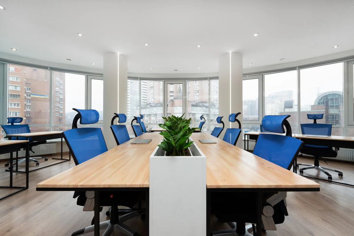 A meeting room with a long table and blue chairs