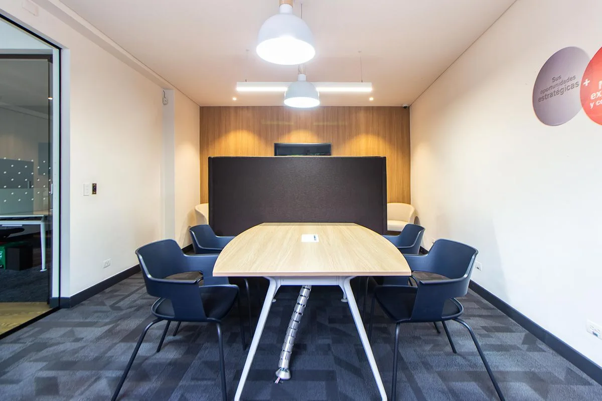 A private meeting room with a long table and padded chairs