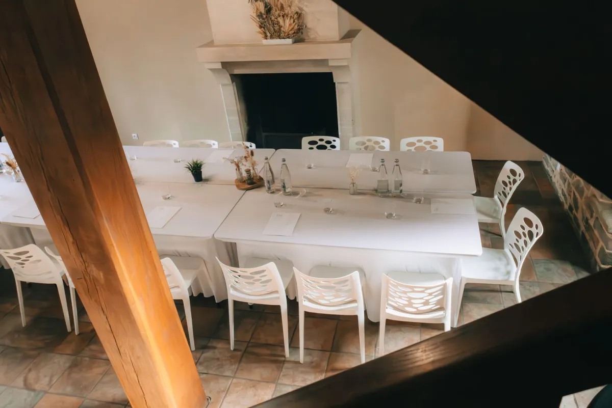 A bright meeting room with a long table and a fireplace