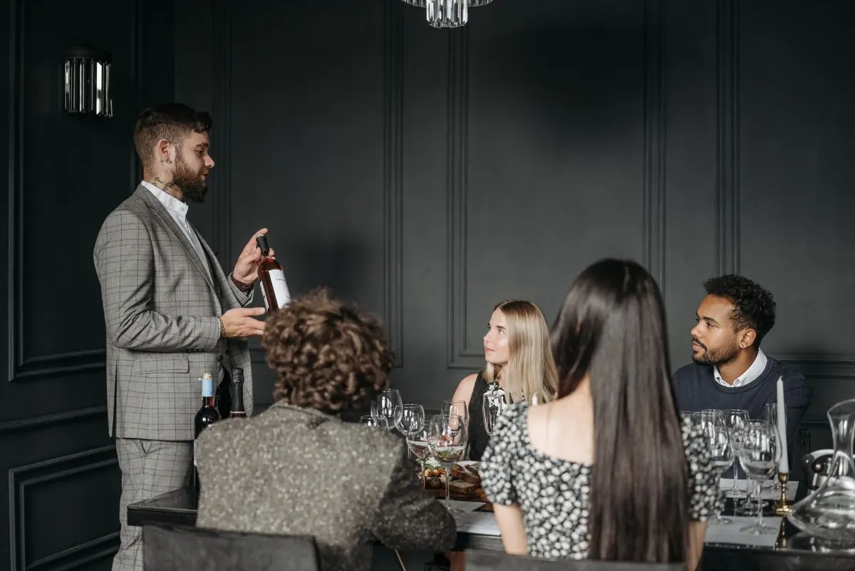 A host introduces a small group to a wine tasting.