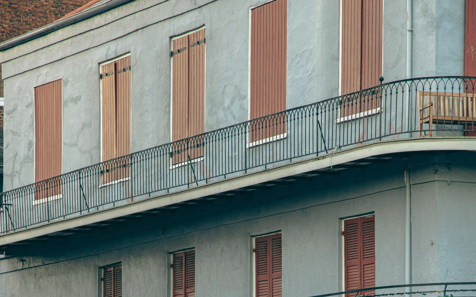 Iron balconies and shuttered windows on a French Quarter building in New Orleans.
