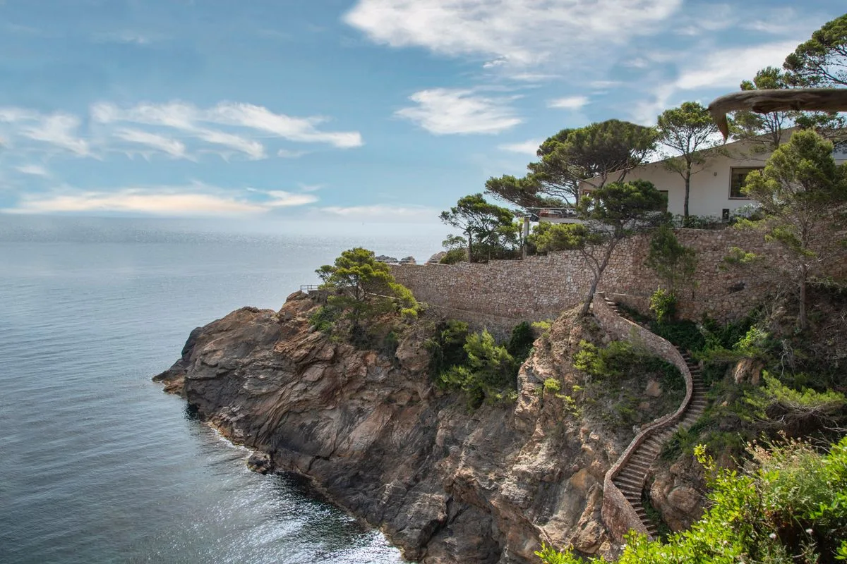 A coastal house above the sea with outdoor terraces