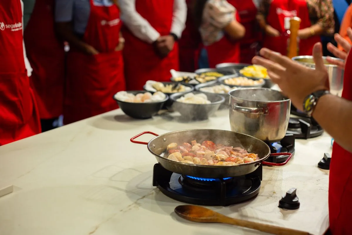 Participants in aprons preparing food during a cooking class