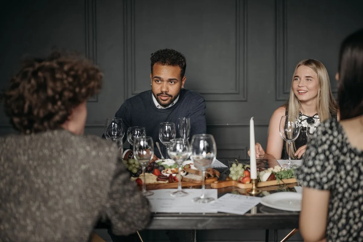 A group sharing food and conversation around a dinner table